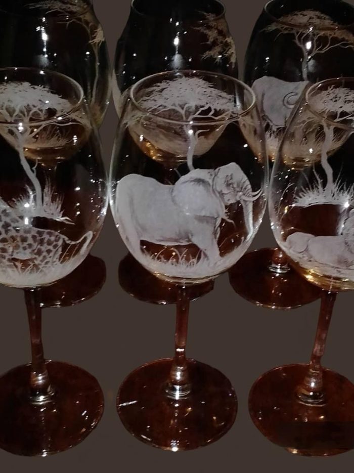 a group of wine glasses with animals and giraffes